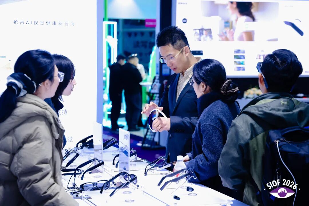 Attendees examine assistive glasses designed for the visually impaired at a technology showcase event.